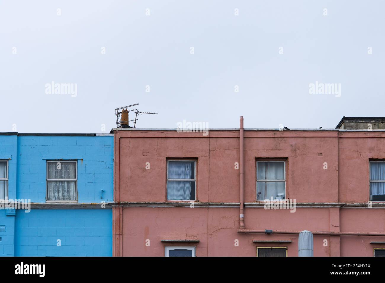 Farbenfrohe, aber vernachlässigte, lackierte Gebäude mit verwittertem und verschlechtertem Äußeren. Stockfoto