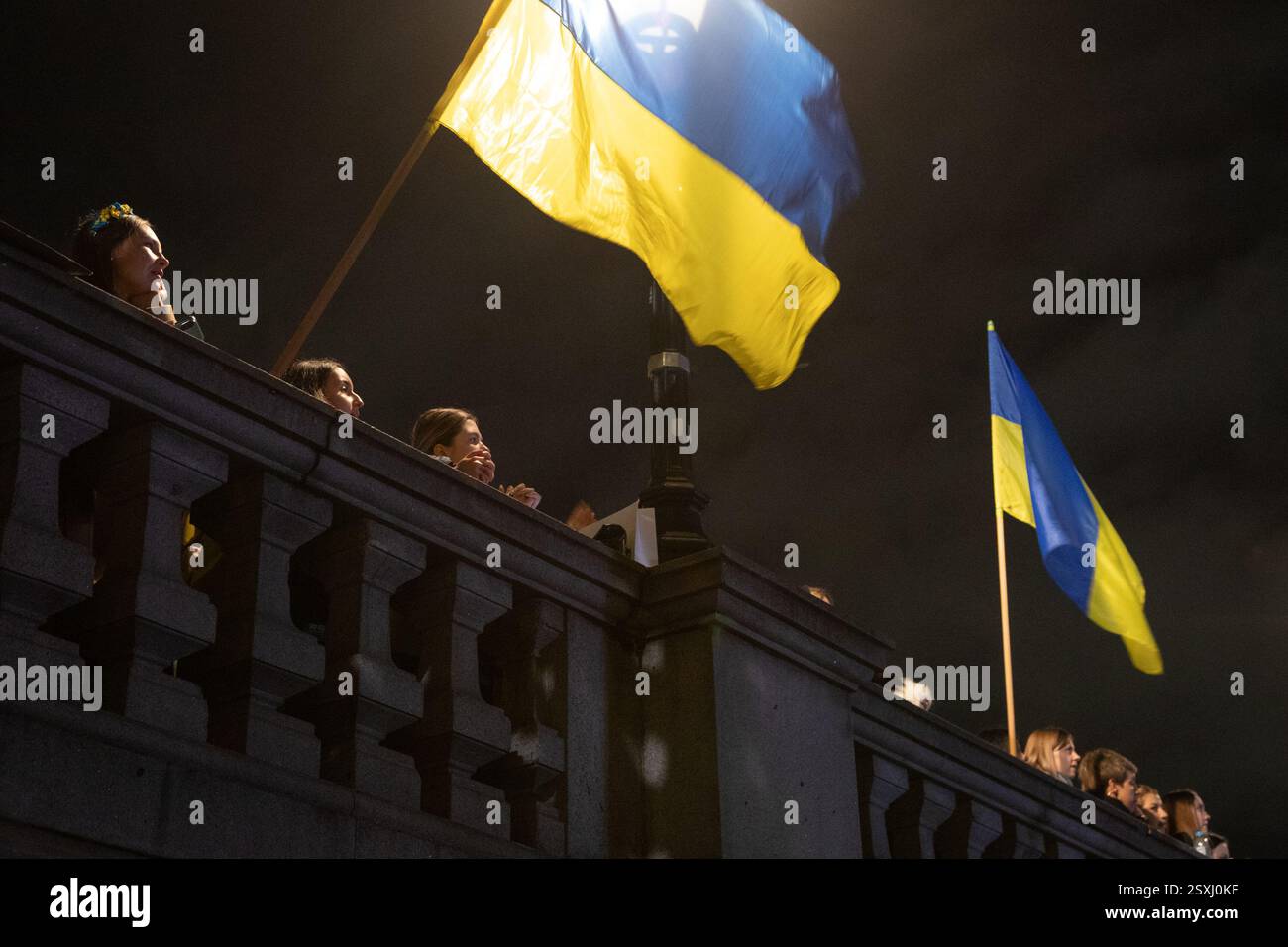 London, England, Großbritannien. Februar 2025. Demonstranten schwenken ukrainische Fahnen auf dem Trafalgar-Platz, wo sich Tausende zum dritten Jahrestag des russischen Angriffs auf die Ukraine versammelt haben. Kredit: Kiki Streitberger/Alamy Live News Stockfoto