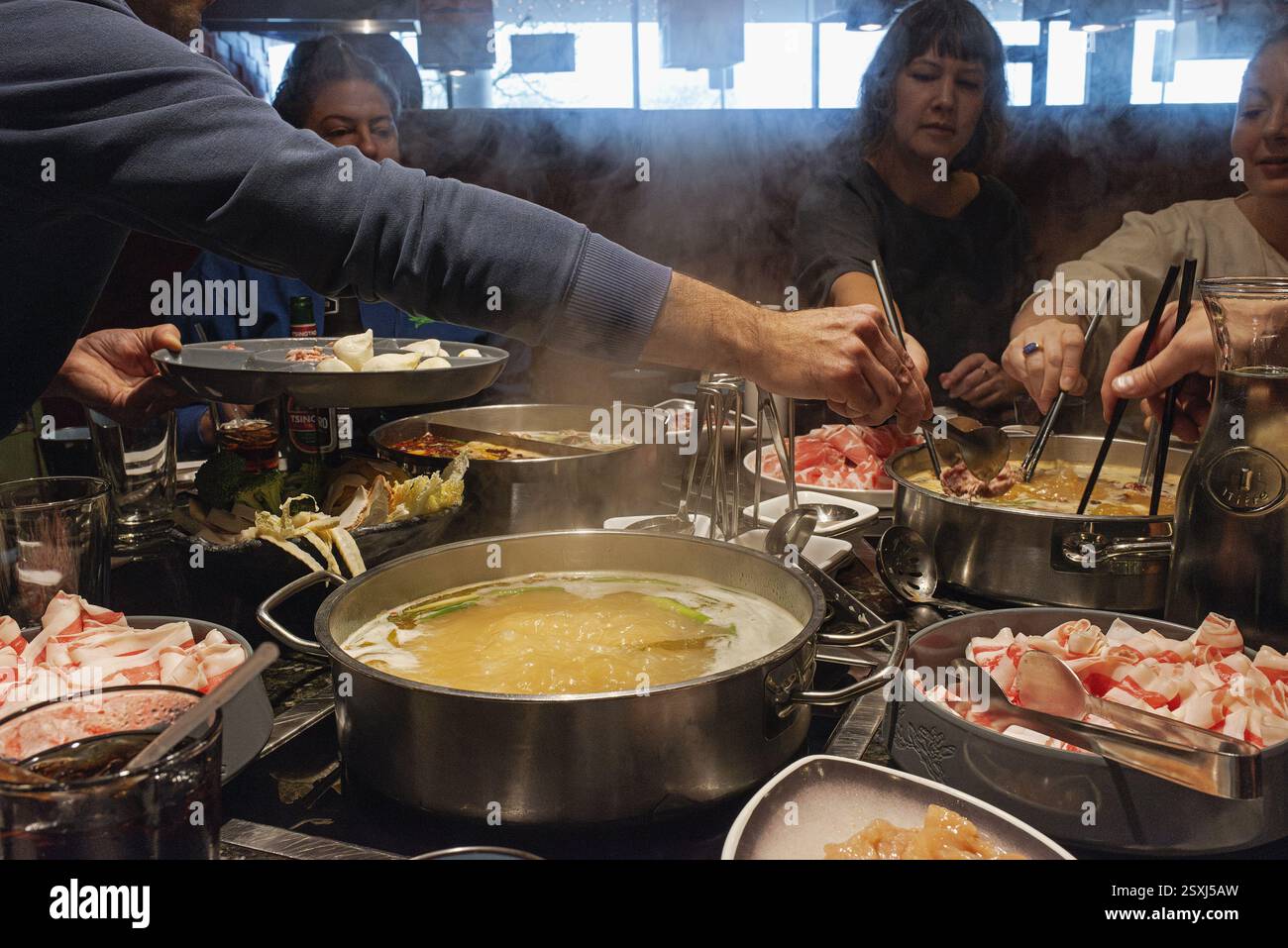Eine Gruppe von Freunden isst Hot Pot in einem Hot Pot Restaurant. Stockfoto