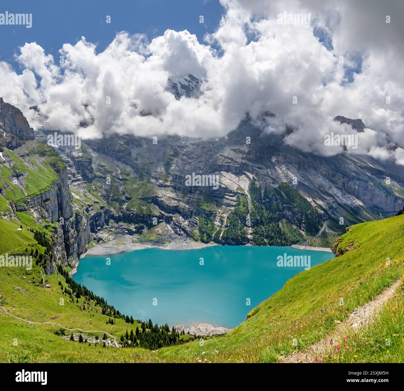 Der Oeschinensee und die Gipfel der Berner alpen in Wolken - Schwitzerland. Stockfoto