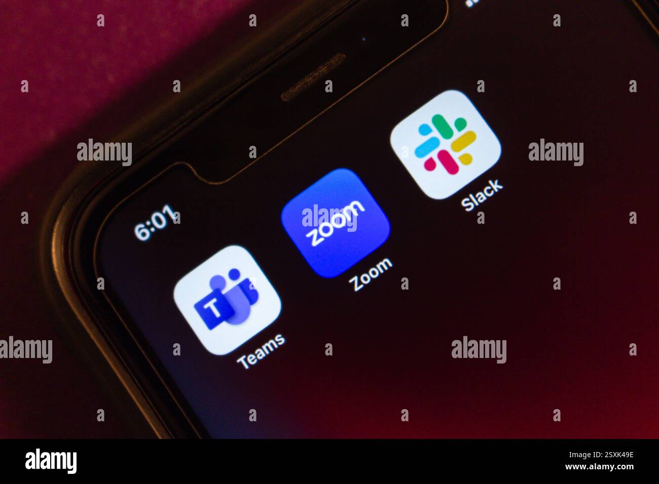 Microsoft Teams, Zoom und Slack Symbole werden auf einem iPhone angezeigt. Moderne Fernarbeit, Kommunikationstools und kollaboratives Arbeitskonzept. Stockfoto