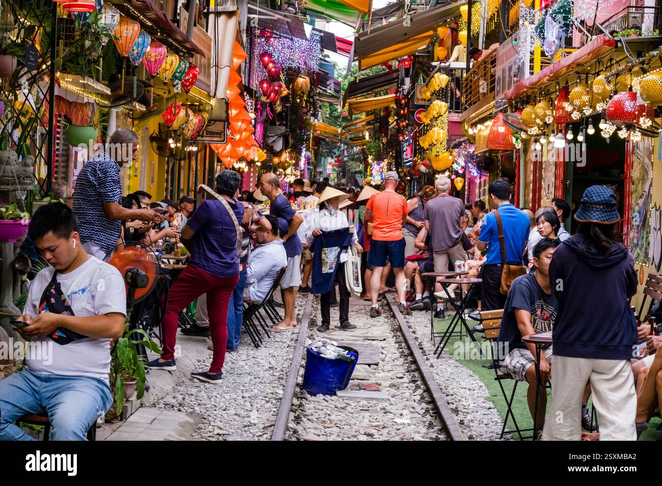 Viele Touristen treffen sich in der bunt dekorierten Train Street, sitzen in den Restaurants im Freien und warten auf den Zug. Stockfoto