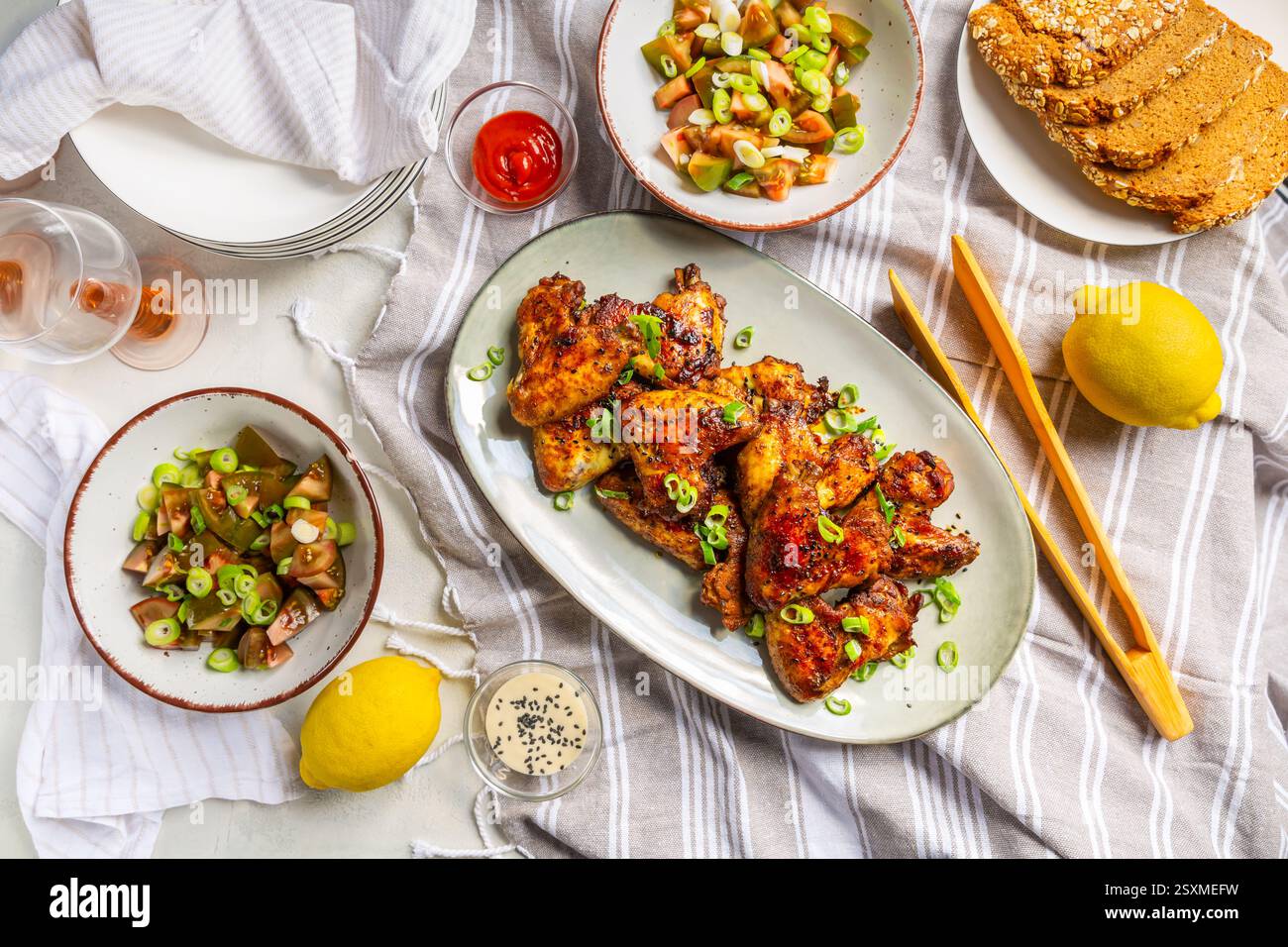Picknicktisch und Essen im Freien, Hähnchenflügel mit gemischtem Salat Stockfoto