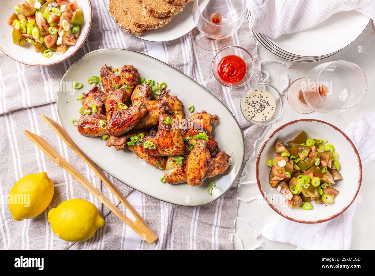 Picknicktisch und Essen im Freien, Hähnchenflügel mit gemischtem Salat Stockfoto
