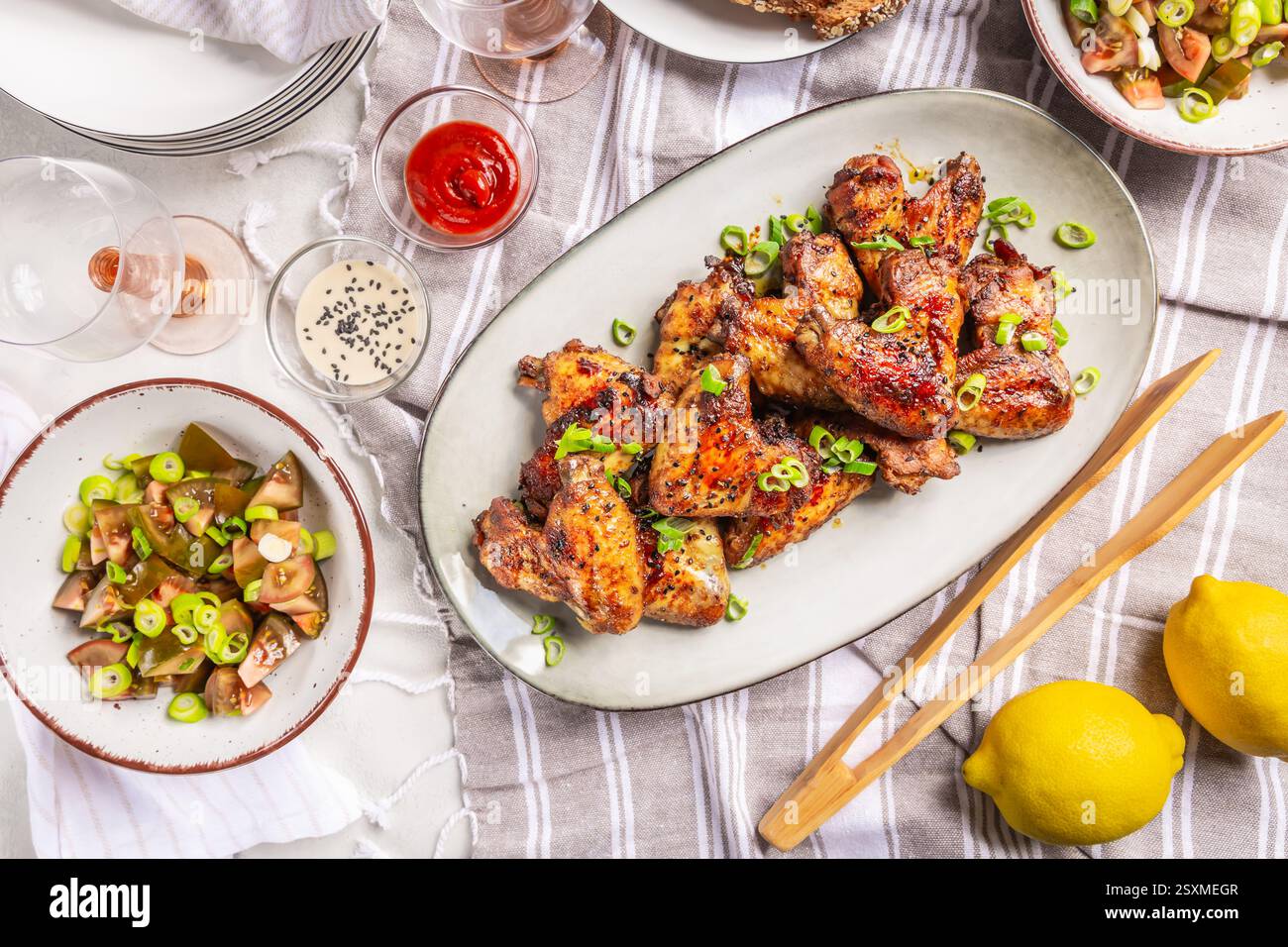 Picknicktisch und Essen im Freien, Hähnchenflügel mit gemischtem Salat Stockfoto