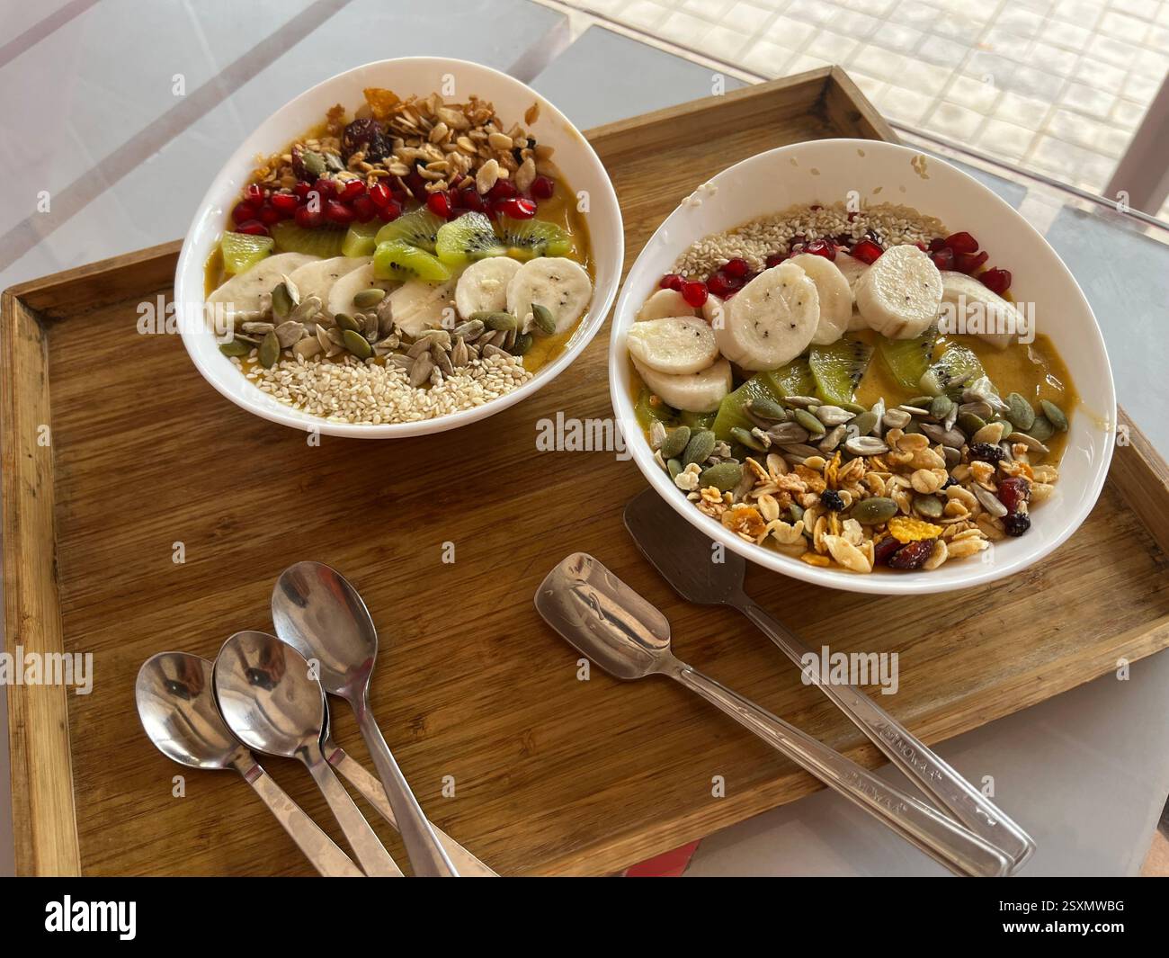 Nahaufnahme einer Schüssel Haferflocken mit cremiger Textur und gesunder Wirkung. Das warme, herzhafte Gericht wird mit frischem Obst und Nüssen belegt. - Smartphone-aufgenommenes Stockfoto