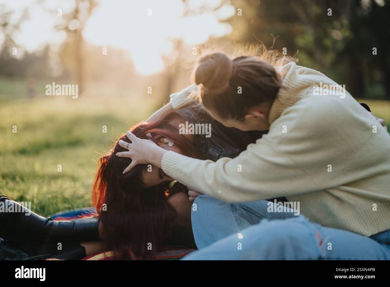 Zwei Personen interagieren spielerisch in einer sonnigen Umgebung im Freien Stockfoto