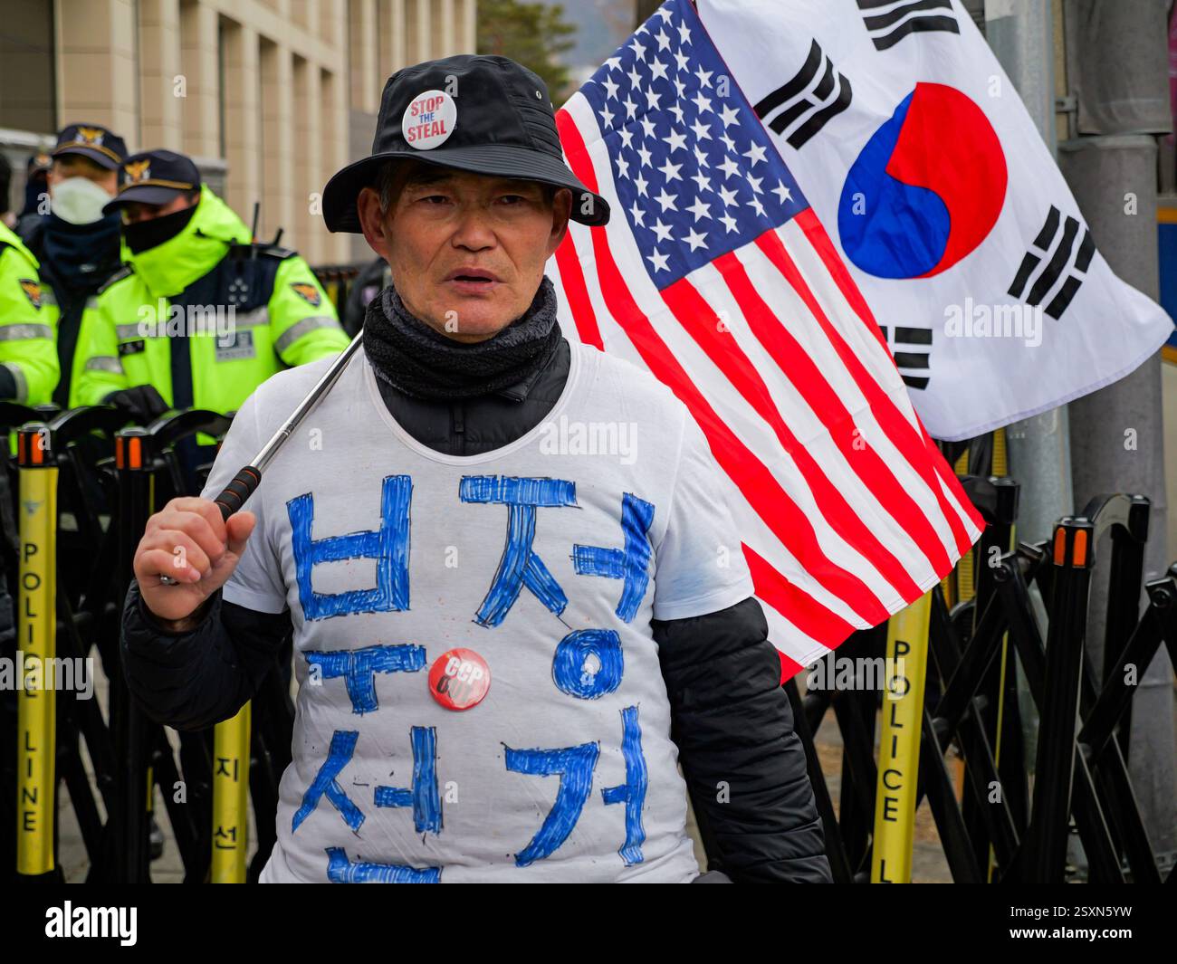 Seoul, Südkorea. Februar 2025. Ein Unterstützer des angeklagten südkoreanischen Präsidenten Yoon Suk-Yeol trägt ein T-Shirt mit Wahlbetrug und trägt amerikanische und südkoreanische Flaggen in der Nähe des Verfassungsgerichts in Seoul, Südkorea, am Dienstag, den 25. Februar 2025. Die letzte Anhörung in Yoons Amtsenthebungsverfahren fand Dienstag statt. Foto: Thomas Maresca/UPI Credit: UPI/Alamy Live News Stockfoto Seoul, Südkorea. Februar 2025. Ein Unterstützer des angeklagten südkoreanischen Präsidenten Yoon Suk-Yeol trägt ein T-Shirt mit Wahlbetrug und trägt amerikanische und südkoreanische Flaggen in der Nähe des Verfassungsgerichts in Seoul, Südkorea, am Dienstag, den 25. Februar 2025. Die letzte Anhörung in Yoons Amtsenthebungsverfahren fand Dienstag statt. Foto: Thomas Maresca/UPI Credit: UPI/Alamy Live News Stockfoto
