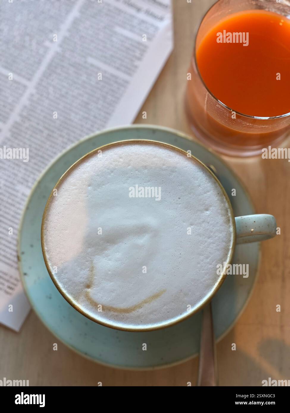 Gemütlicher Morgenkaffee mit frischem Saft und Zeitung Stockfoto