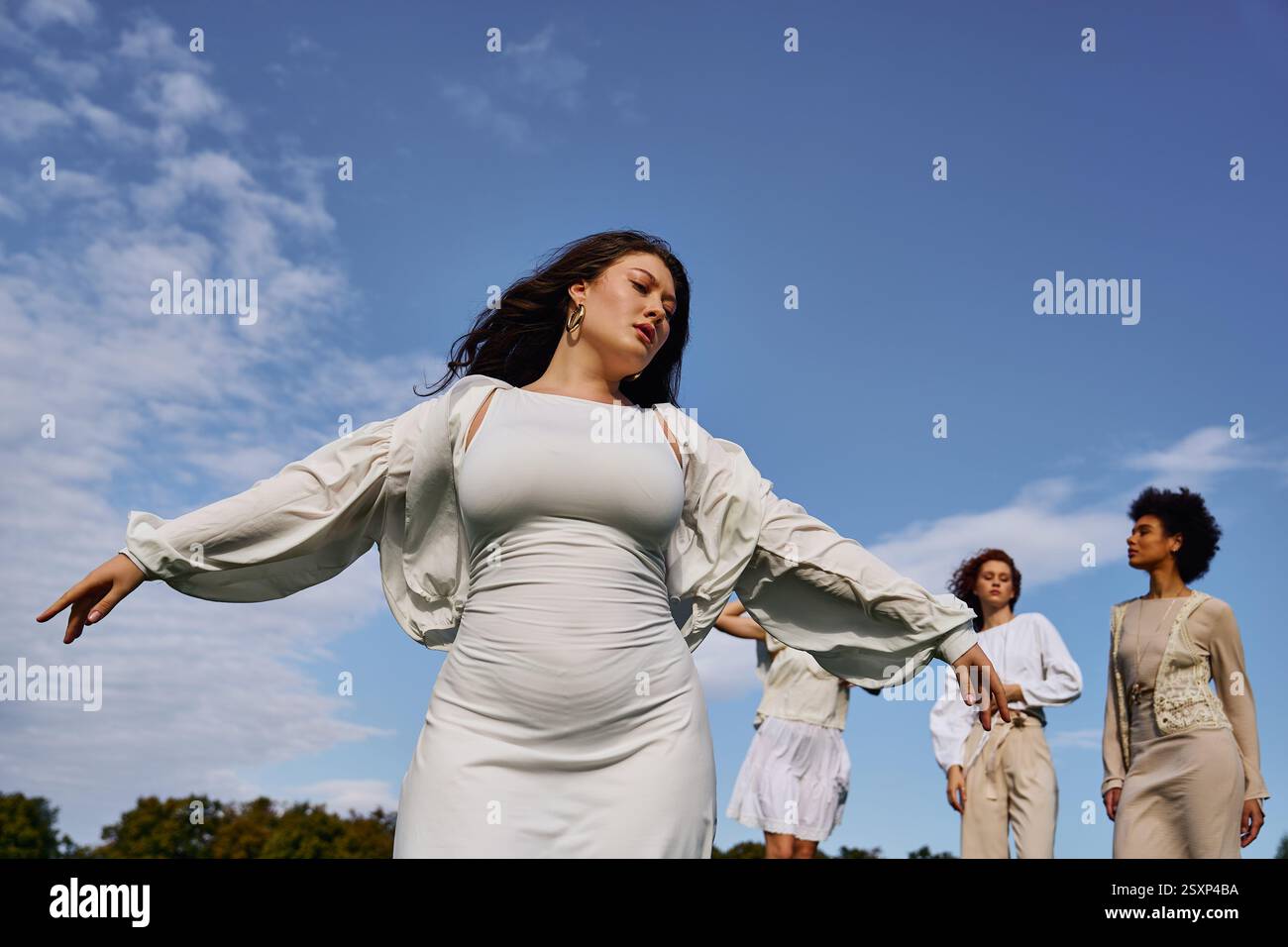Eine stilvolle Gruppe selbstbewusster Frauen begrüßt die Schönheit der Natur in einem Park im Frühling. Stockfoto