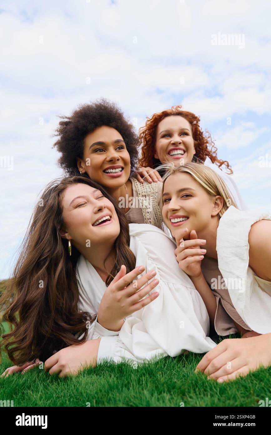 Vier selbstbewusste Frauen bringen ihre Freude in einer sonnendurchfluteten Umgebung inmitten der Natur zum Ausdruck. Stockfoto