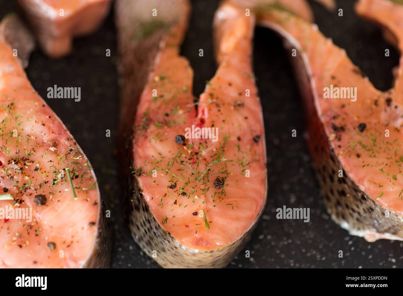 Rohe Stücke von rotem Fisch mit Gewürzen. Stockfoto