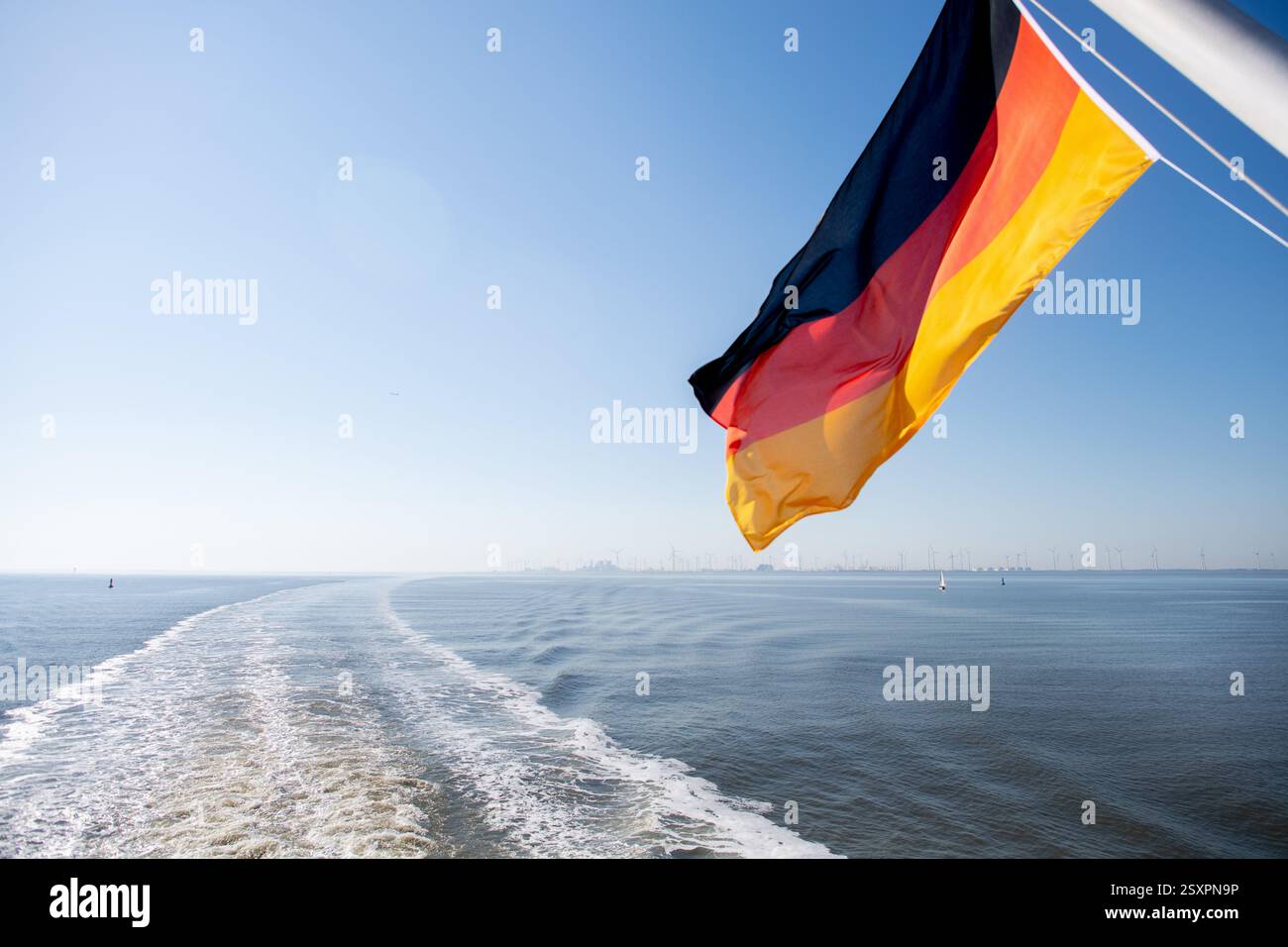 Borkum, Deutschland. Juni 2024. Eine Flagge der Bundesrepublik Deutschland fliegt auf einer Fähre der AG Ems während der Überfahrt zur Insel Borkum. Die Reederei betreibt den Fährdienst von Emden und dem niederländischen Hafen Eemshaven zur westlichsten Nordseeinsel Deutschlands. Quelle: Hauke-Christian Dittrich/dpa/Alamy Live News Stockfoto