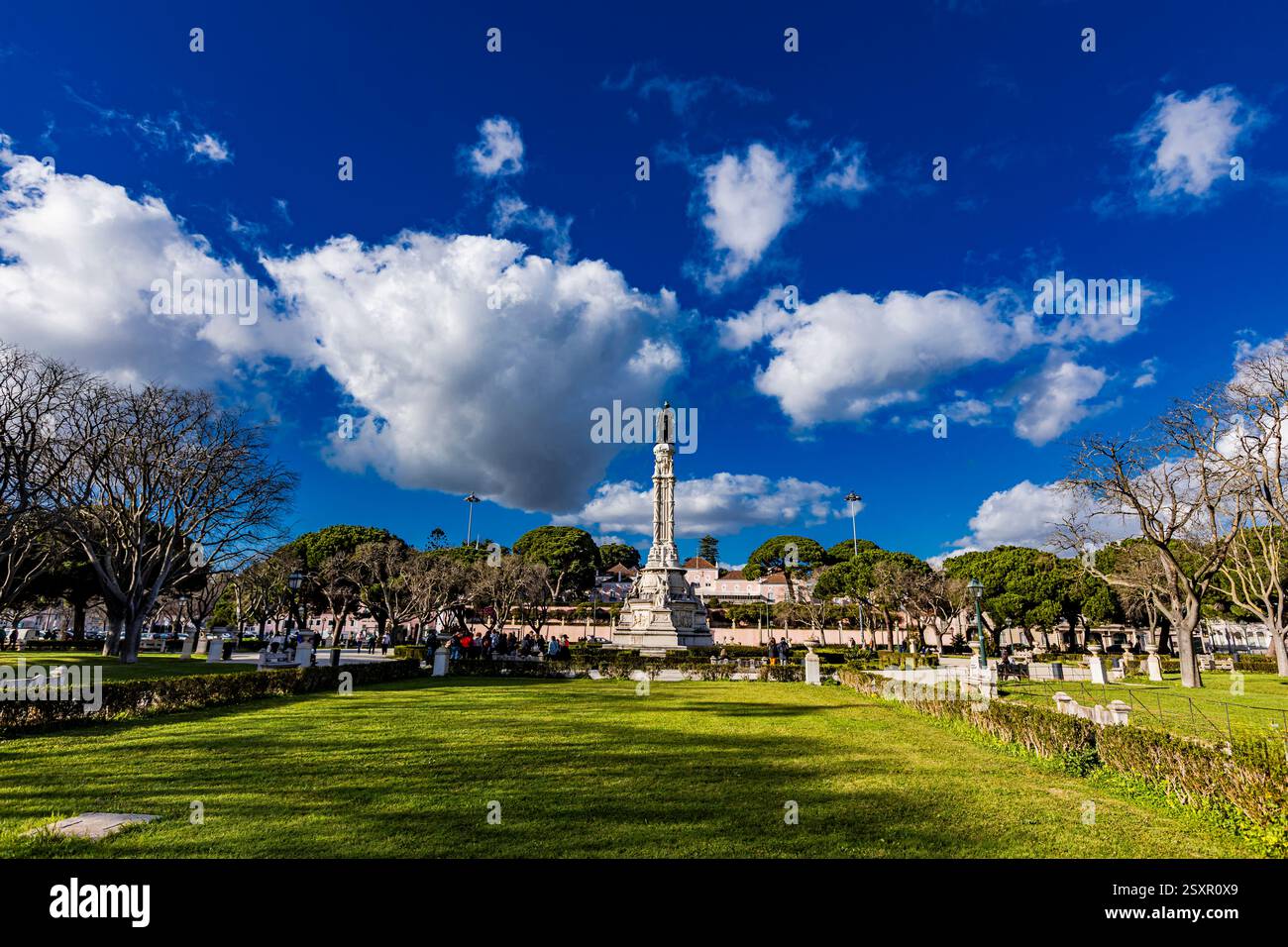 In lissabon, Portugal, ist das eindrucksvolle Monument, das Afonso de Albuquerque gewidmet ist, von üppigem Grün und blühenden Bäumen umgeben, was eine ruhige Atmosphäre schafft Stockfoto
