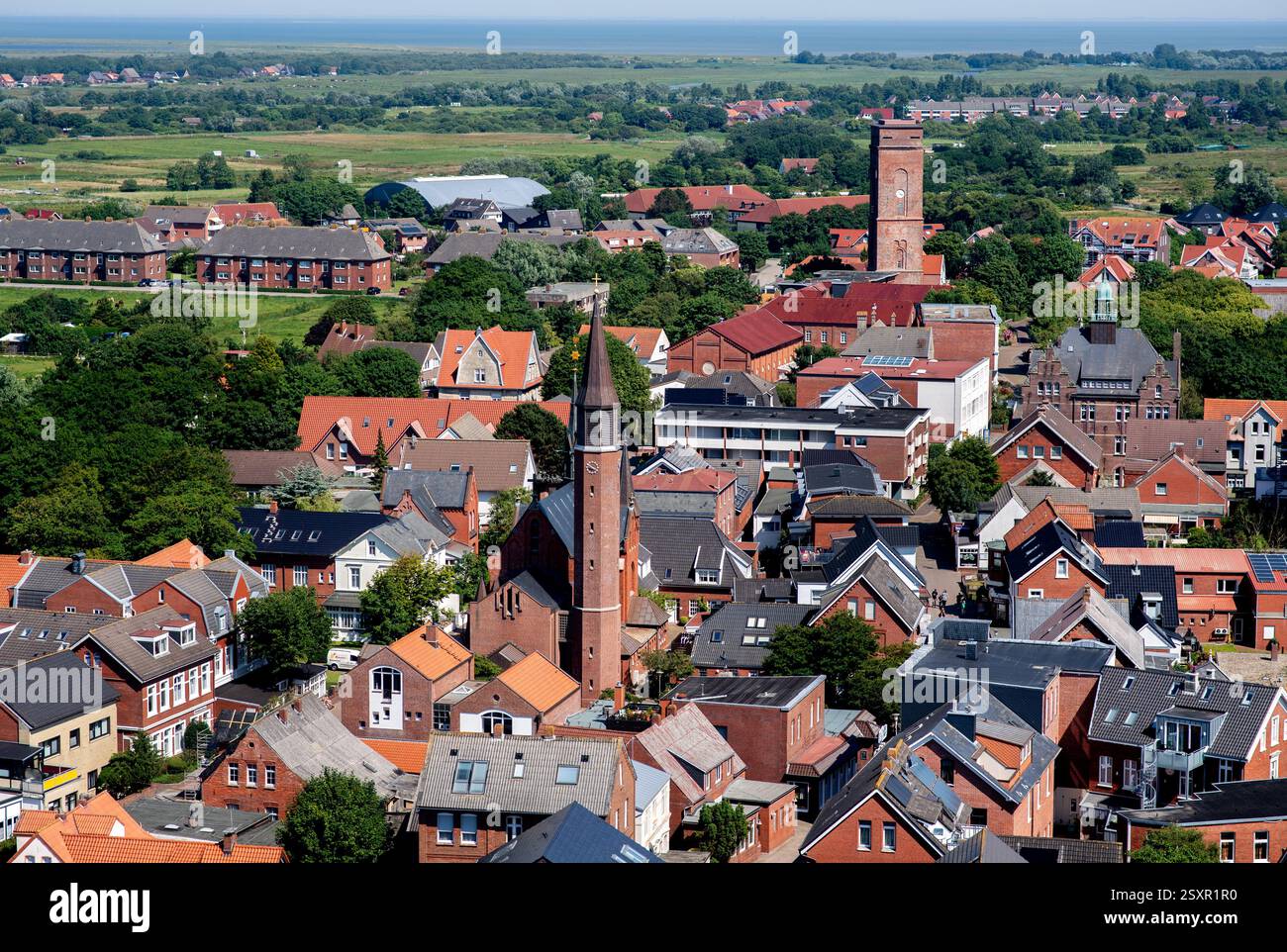 Borkum, Deutschland. Juni 2024. Zahlreiche Häuser sowie die katholische Kirche Maria Meeresstern und der Alte Leuchtturm (dahinter) befinden sich im Ortskern der Nordseeinsel Borkum, fotografiert vom Neuen Leuchtturm. Quelle: Hauke-Christian Dittrich/dpa/Alamy Live News Stockfoto