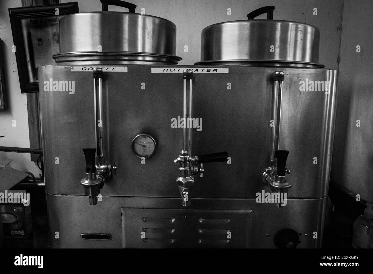 Kommerzielle Kaffeeurnen im Restaurant-Stil aus Edelstahl für die Abgabe von heißem Kaffee und heißem Wasser. Schwarz-weiß. Stockfoto