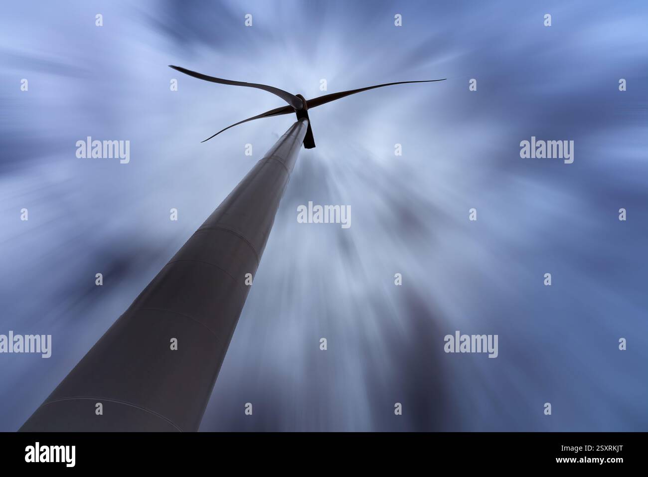 Windenergieanlage zur Erzeugung erneuerbarer Energie unter dynamischem, bewölktem Himmel Stockfoto