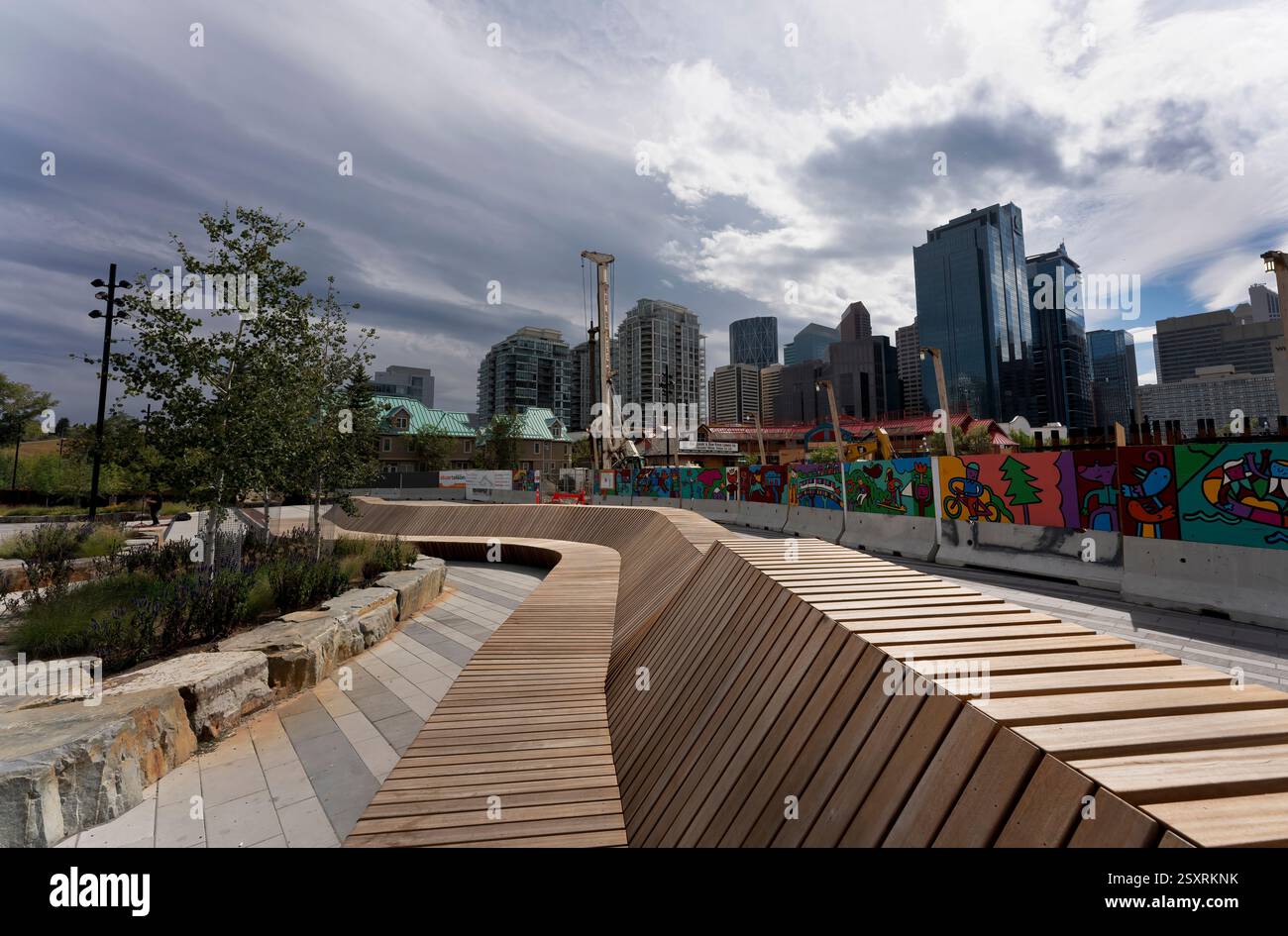 Moderner Holzsteg in einem Park mit Blick auf die Skyline von calgary, alberta, kanada, unter bewölktem Himmel Stockfoto