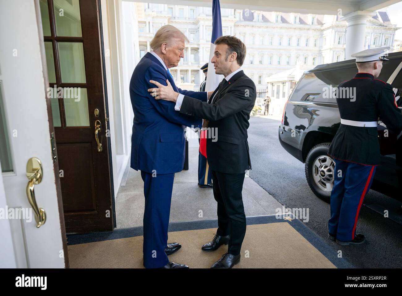 Präsident Donald Trump begrüßt den französischen Präsidenten Emmanuel Macron am Montag, den 24. Februar 2025, in der Lobby im Westflügel des Weißen Hauses. (Offizielles Foto des Weißen Hauses von Daniel Torok) Stockfoto