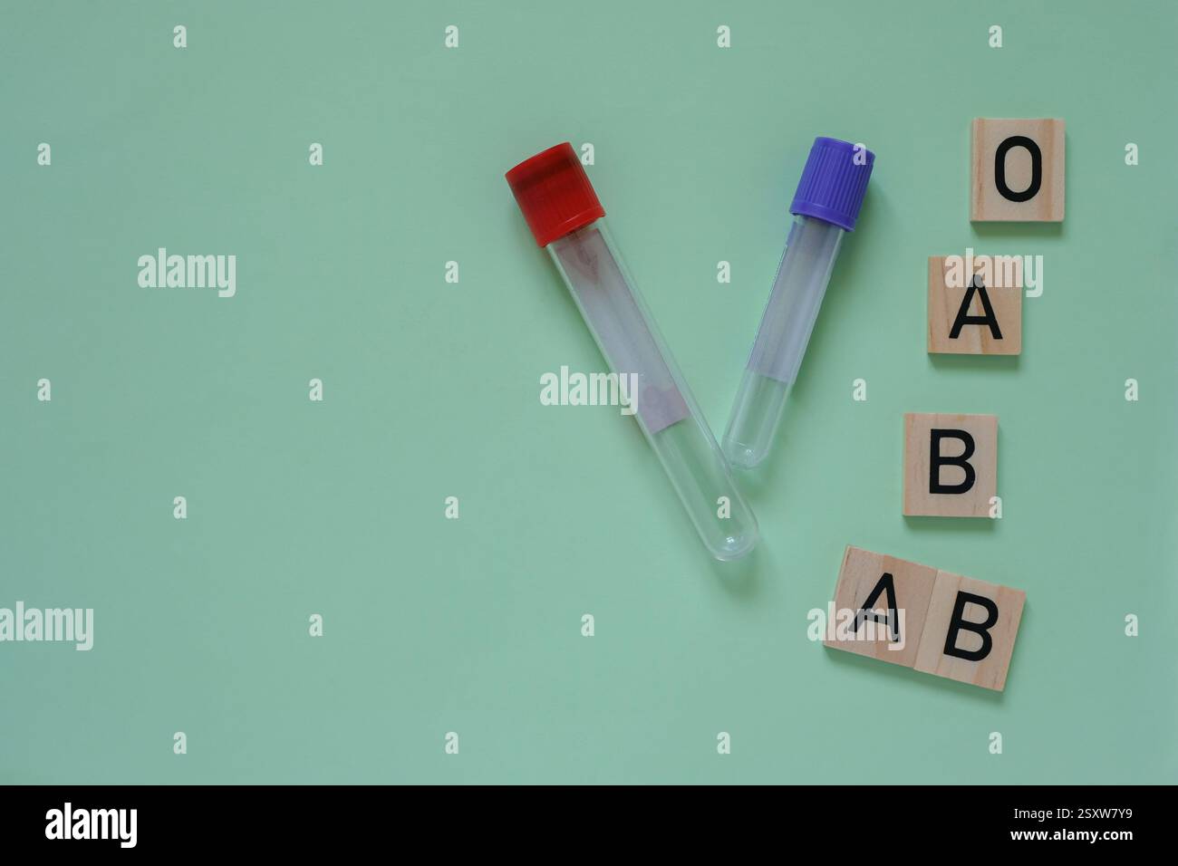 Reagenzgläser mit roten und violetten Stopfen. Holzwürfel mit Buchstaben repräsentieren verschiedene Blutgruppen mittlere aquamarinfarbene Hintergründe. Kopierbereich. Stockfoto