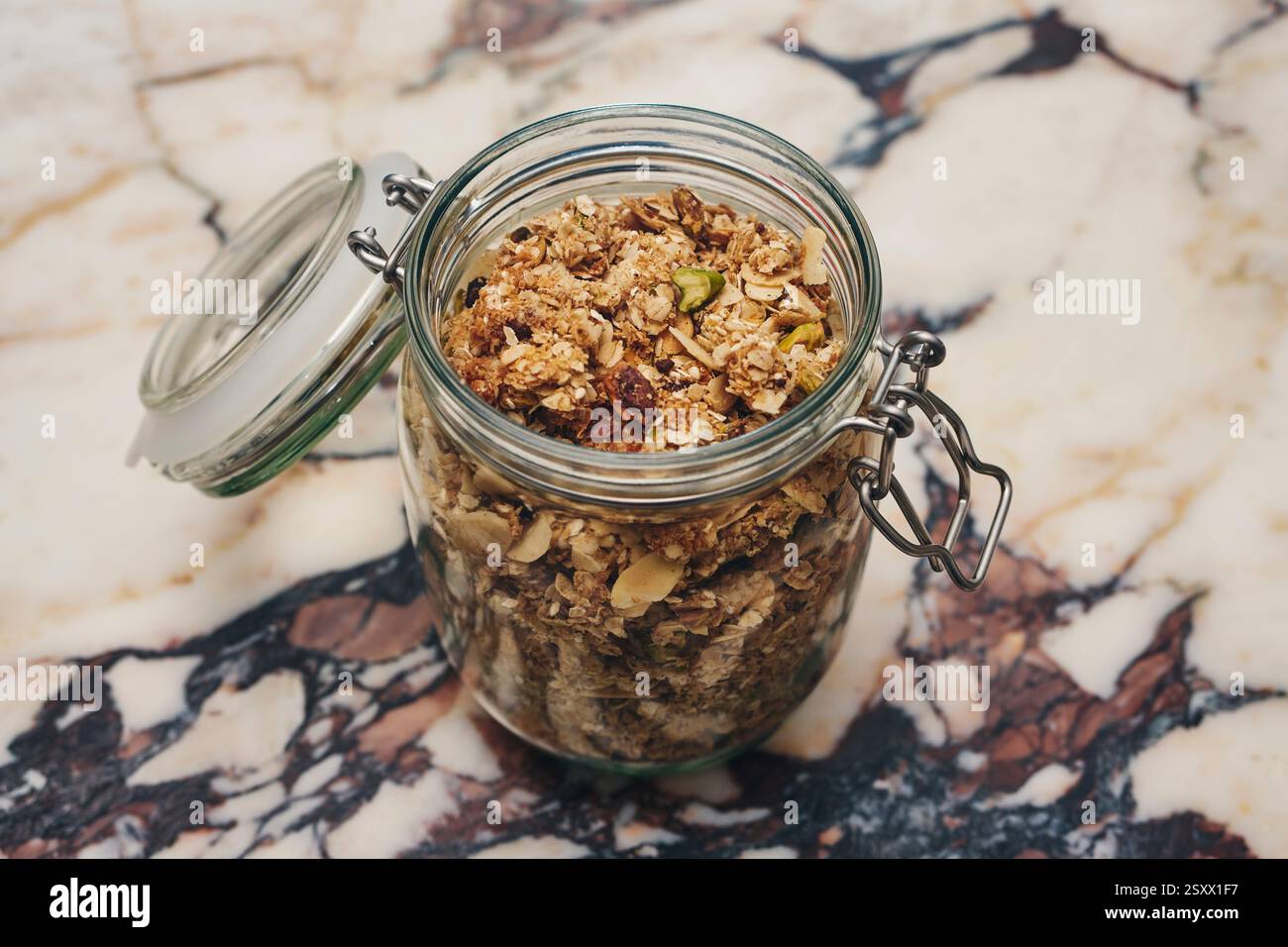 Schließen Sie frisches Müsli in einem Glas auf Marmoroberfläche Stockfoto