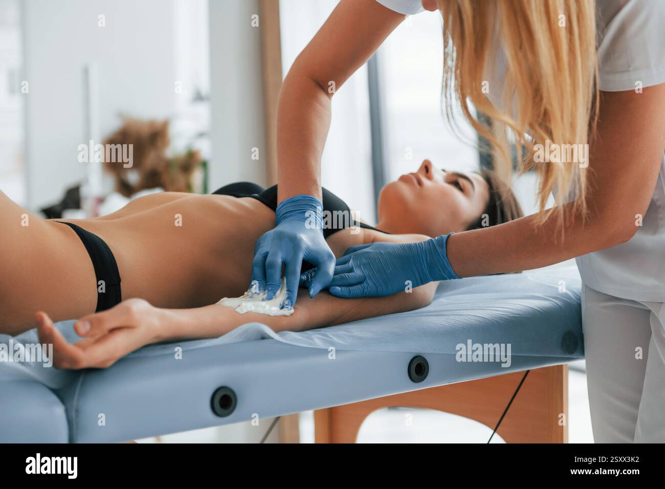 Frau wird in der Klinik von einer Ärztin mit Zucker behandelt. Stockfoto