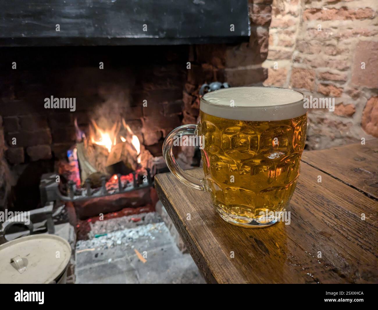 Ein Bier am Kamin in einem Pub in Cumbria, Großbritannien Stockfoto