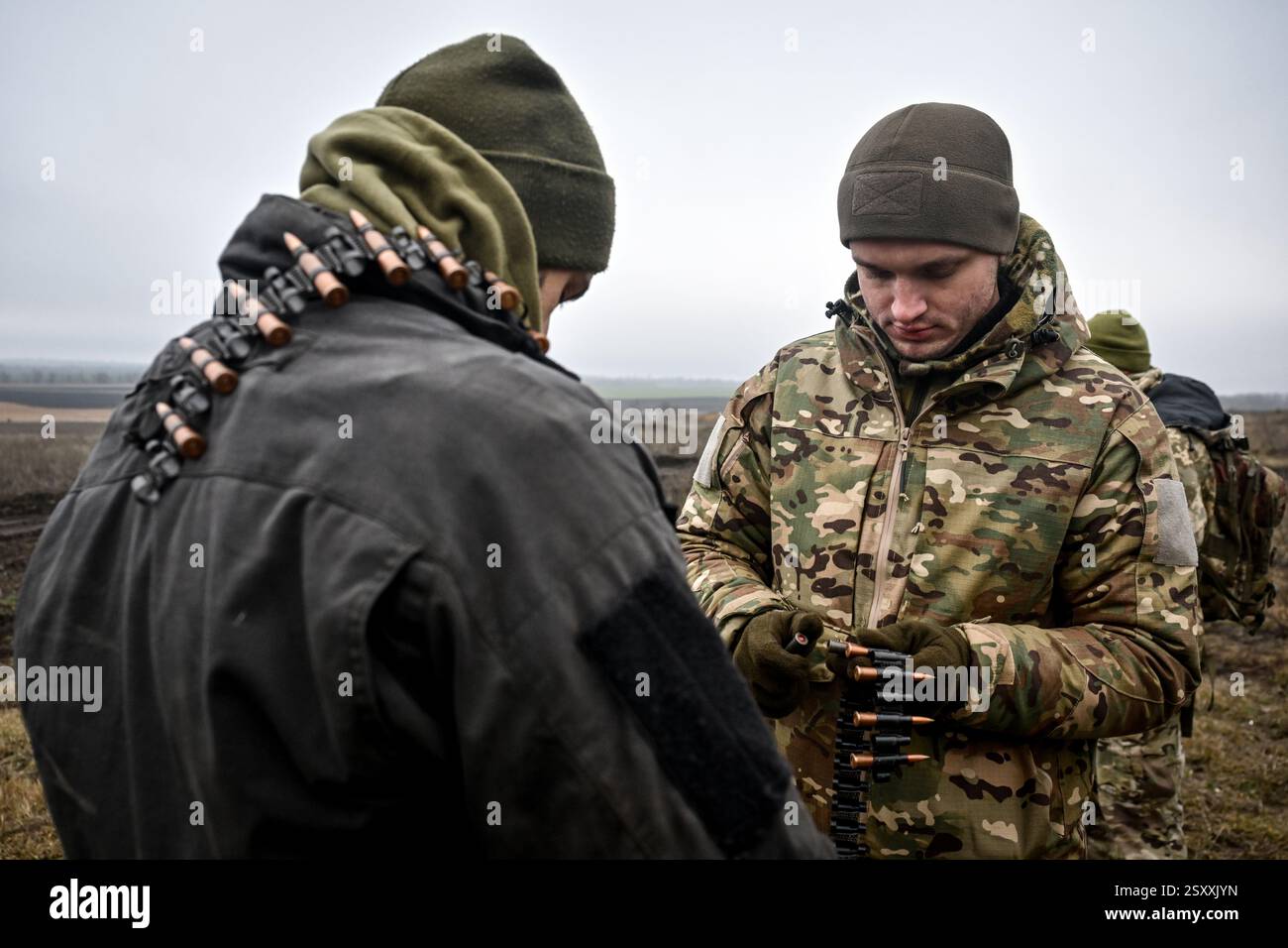 Während einer Feuerübung eines Panzerbataillons der 128. Gebirgsbrigade der ukrainischen Streitkräfte am 28. Januar 2025 wurden Patronen in einen Maschinengewehrgürtel gelegt. (Foto: Dmytro Smolienko/Ukrinform) Stockfoto