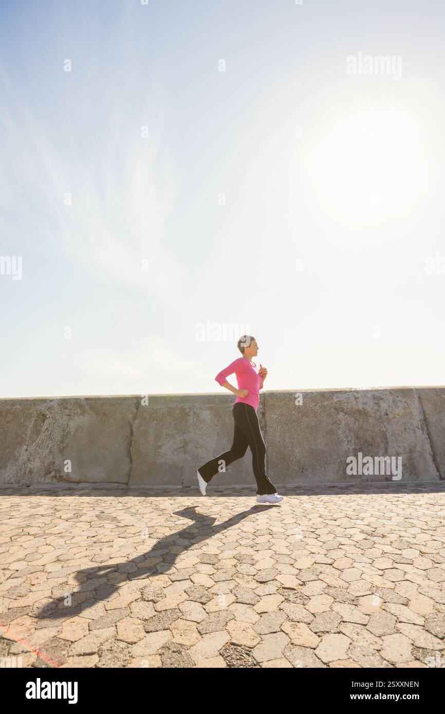 Frau joggt entlang der sonnigen Promenade, genießt Morgentraining und frische Luft, Kopierraum Stockfoto