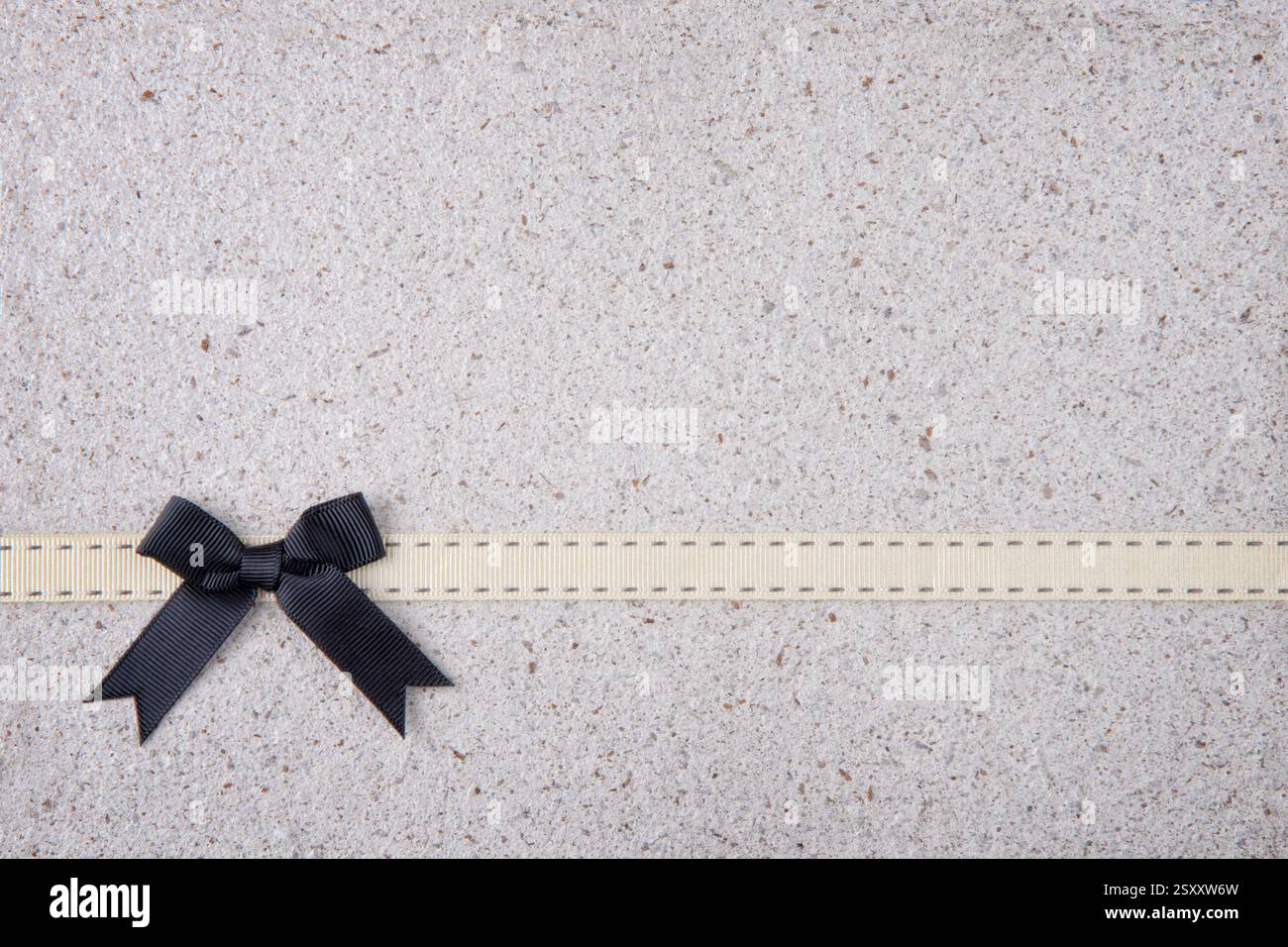 Schwarzes Retro-Band und Bogen über echtem handgemachtem Papierhintergrund Stockfoto