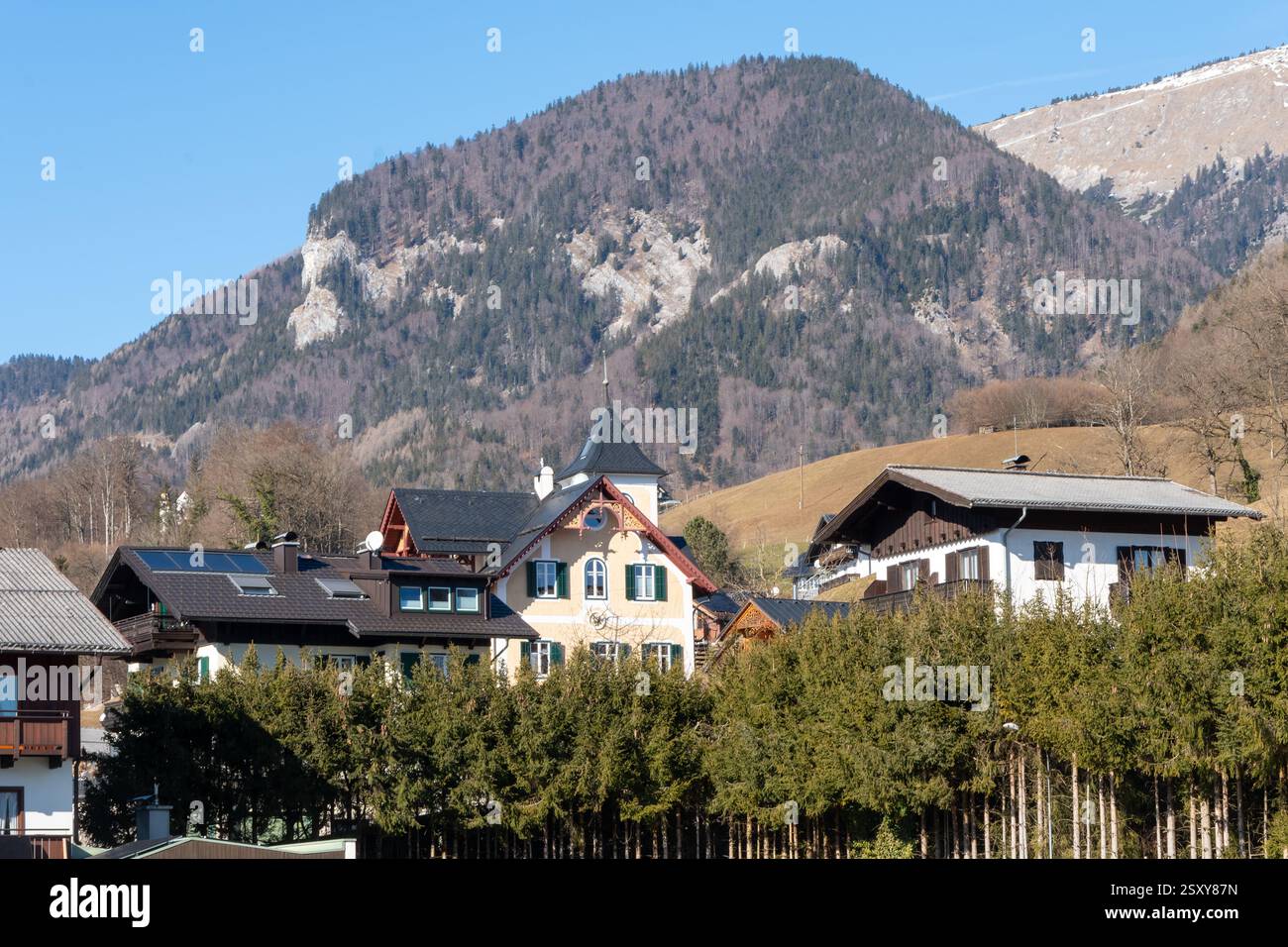 Ein malerisches Bergdorf mit Bergkulisse - gemütliche Häuser im traditionellen Stil, umgeben von Grün und majestätischen Bergen Stockfoto