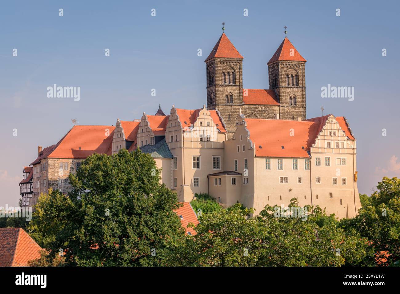 Quedlinburg, Deutschland – 29. August 2024: In einer heißen Augustnacht untergeht die Sonne an der Stiftskirche St. Servatii und der Burg Quedlinburg. Stockfoto