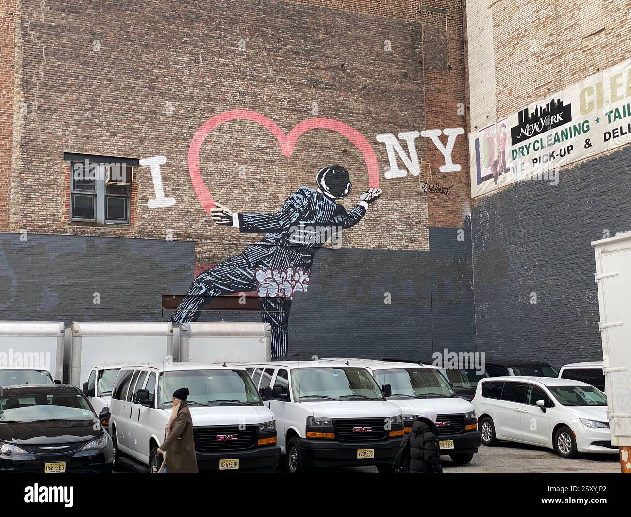 Graffiti in New York an einer Ziegelwand. Es zeigt eine Figur, die ein Herz malt zum Schriftzug „I love NY“ Stockfoto Graffiti in New York an einer Ziegelwand. Es zeigt eine Figur, die ein Herz malt zum Schriftzug „I love NY“ Stockfoto