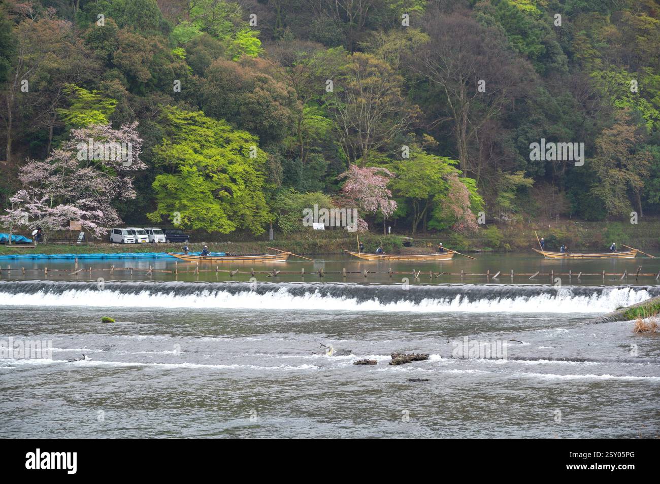 Touristen an der Togetsu-kyo-Brücke, einer Holzbrücke, die den Katsura-Fluss vor den Arashiyama-Bergen in Kyoto, Japan überspannt. Stockfoto