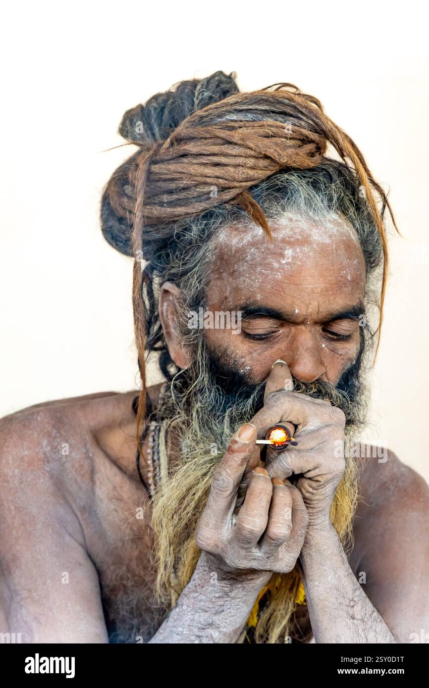 Spiritueller hindu-Naga-heiliger, der Marihuanapöfen bei Mahakumbh Mela anzündet Stockfoto