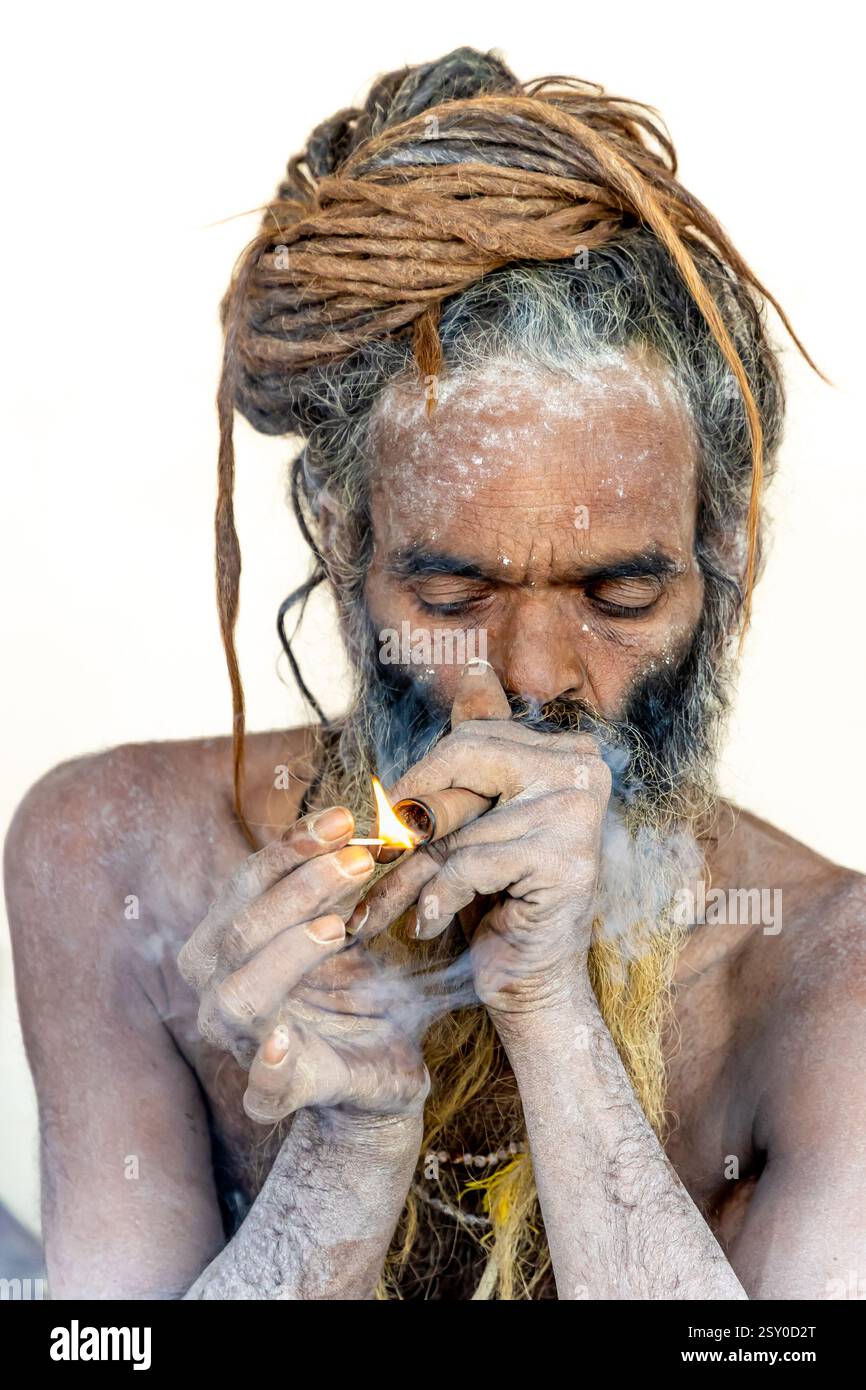 Spiritueller hindu-Naga-heiliger, der Marihuanapöfen bei Mahakumbh Mela anzündet Stockfoto