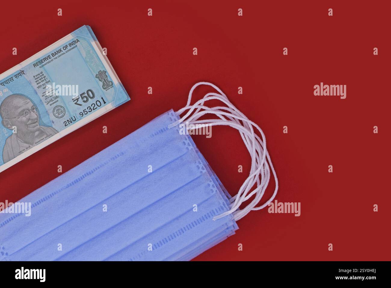 Chirurgische Masken und indisches Geld, Banknoten und Pillen der chirurgischen Maske, globales Pandemiekonzept Stockfoto