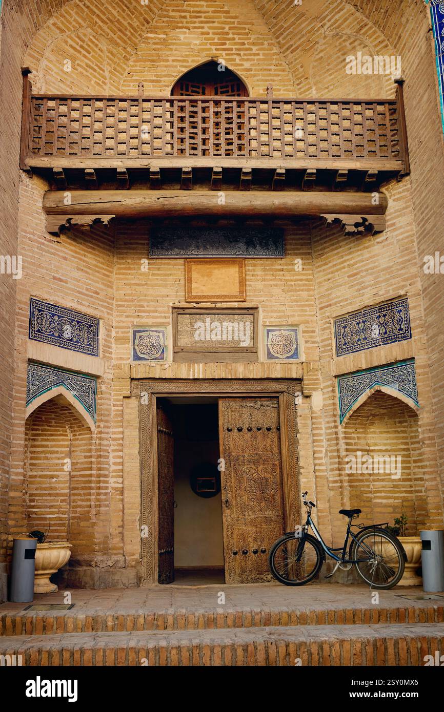 Matniyaz Divanbegi Madrassah Eingang Bogentor und altes Fahrrad in der Nähe in der Altstadt Chiwa in Usbekistan Stockfoto