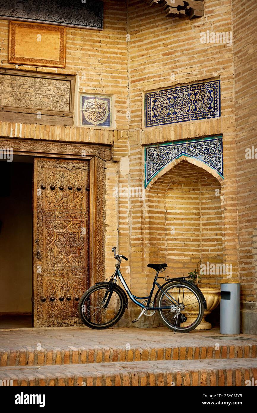 Matniyaz Divanbegi Madrassah Eingang Bogentor und altes Fahrrad in der Nähe in der Altstadt Chiwa in Usbekistan Stockfoto