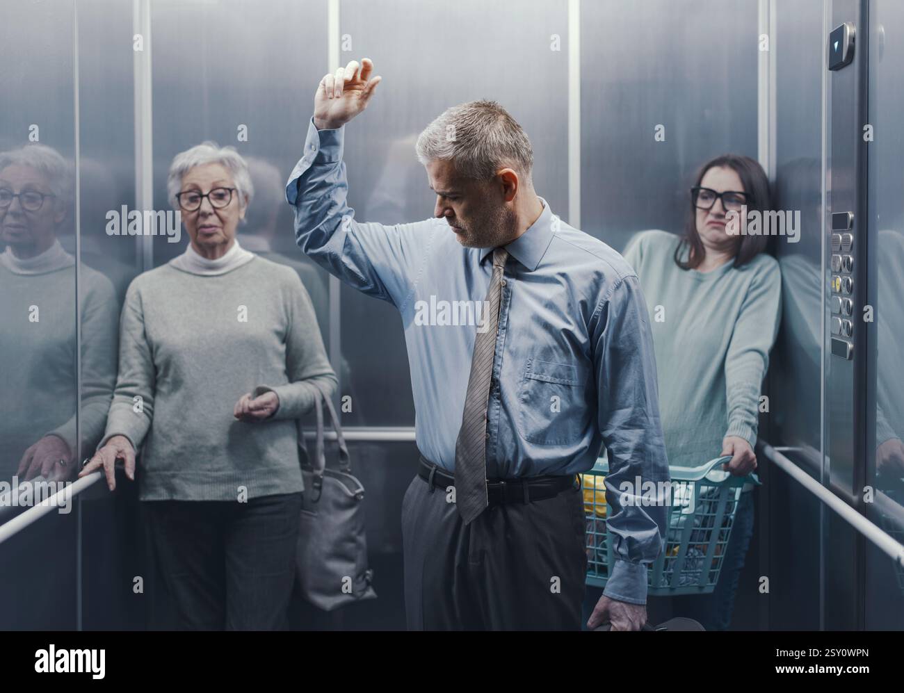 Peinlicher Mann mit schwitzenden, stinkenden Achseln in einem überfüllten Aufzug, die anderen Leute starren ihn an und fühlen sich angeekelt Stockfoto