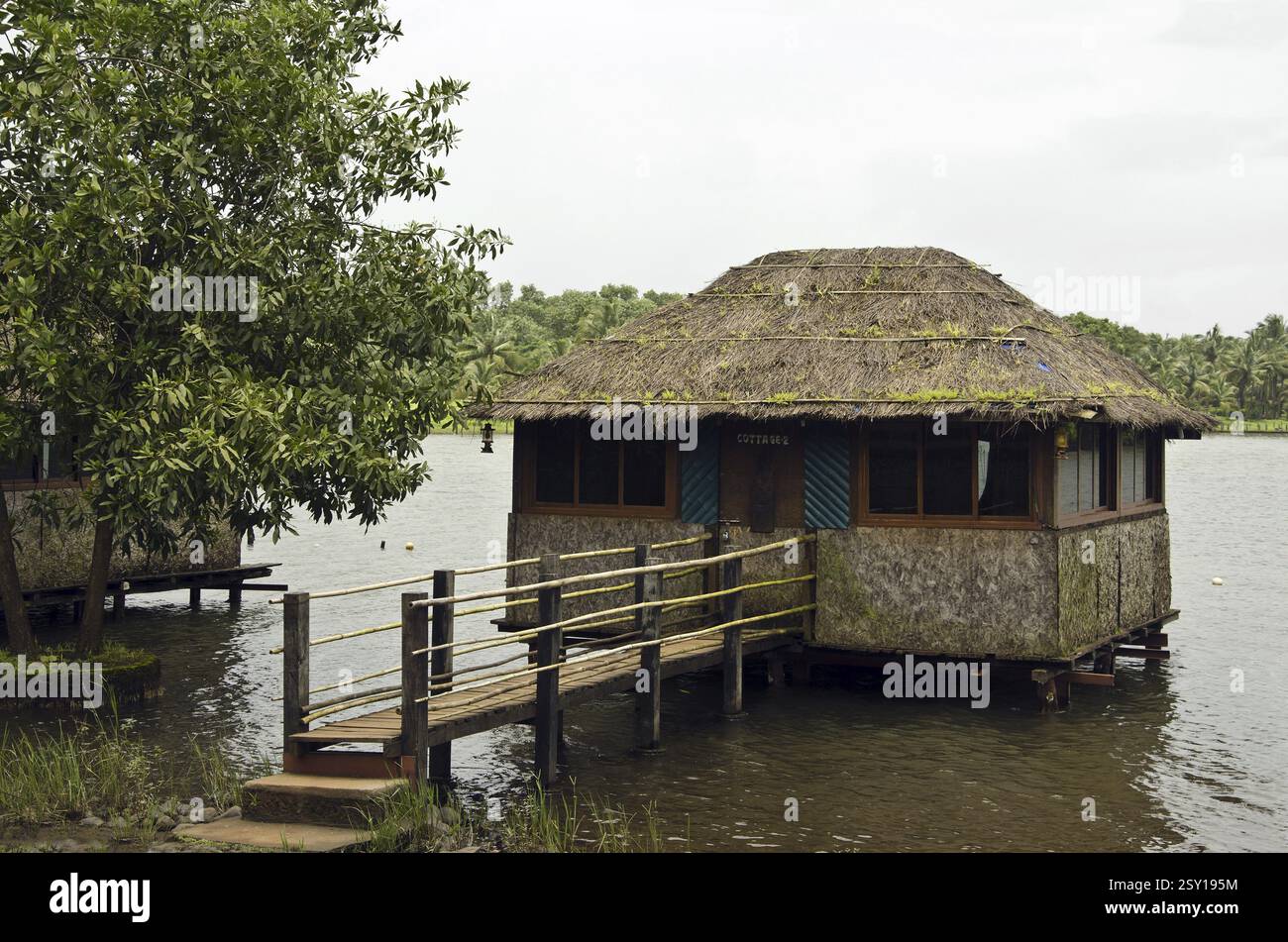Strohdach-Hütte auf dem Wasser unterstützt hölzerne Stümpfe Raigad Maharashtra Indien Asien Stockfoto