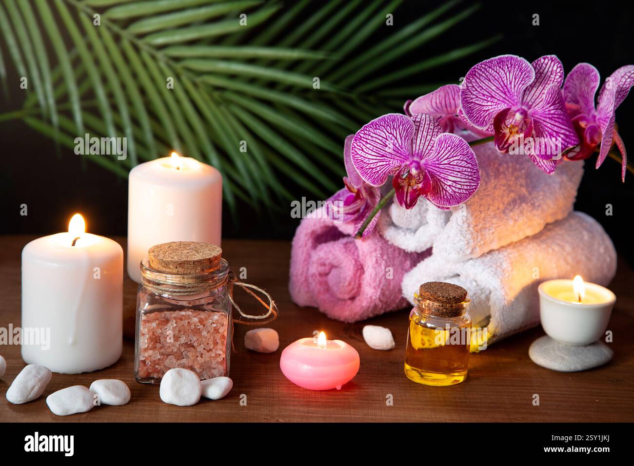 Beauty Arrangement mit aromatischem Öl, brennenden Kerzen und einer Orchidee Stockfoto