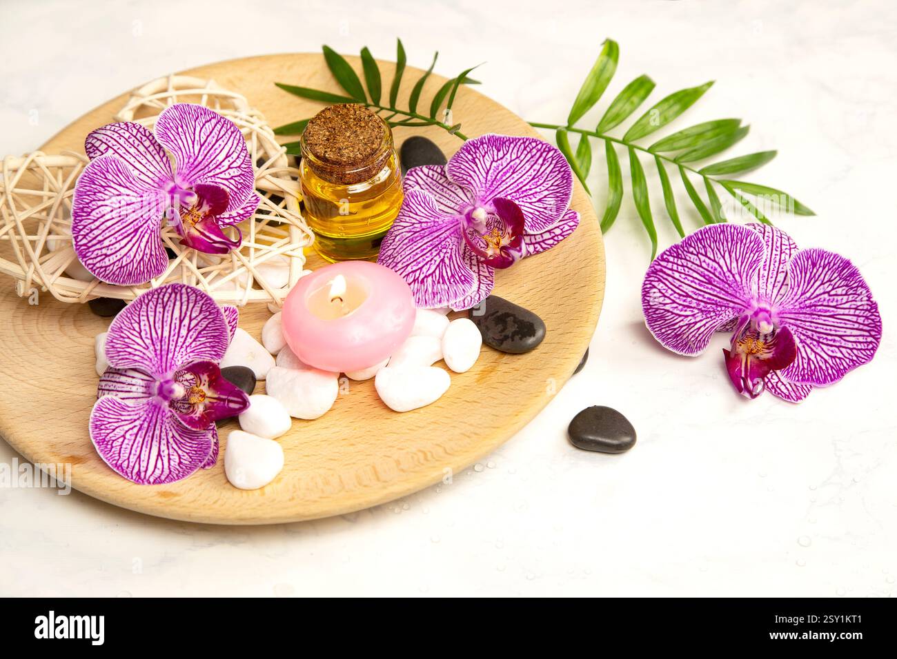 Beauty Arrangement mit aromatischem Öl, brennenden Kerzen und einer Orchidee Stockfoto