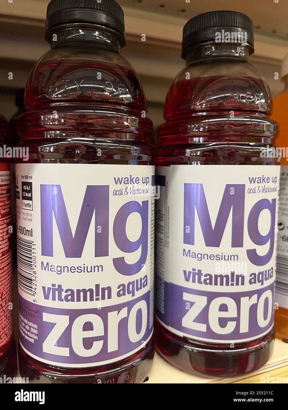 Wasser mit Vitamin-Aqua-Geschmack und Magnesiumflaschen im Supermarktregel, mit Vitaminen angereicherte Getränke, Magnesiumpräparat - Smartphone-aufgenommenes Stockfoto