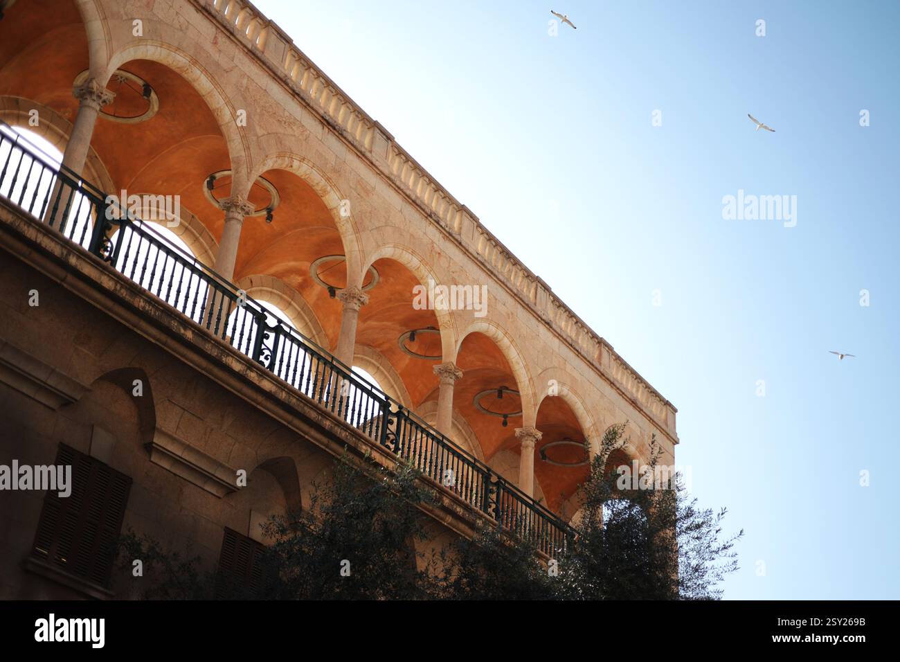 Alte Bausteinbögen des Mittelalters tagsüber gegen den Himmel Möwen, die am Himmel fliegen. Stockfoto
