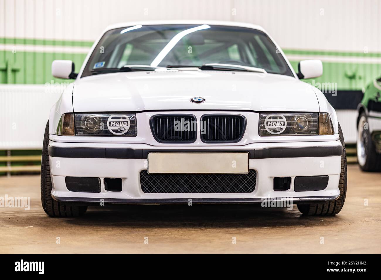 Riga, Lettland - 31. Januar 2025: Eine atemberaubende Vorderansicht eines klassischen weißen BMW E36, der sein kultiges und zeitloses Design wunderschön zeigt Stockfoto