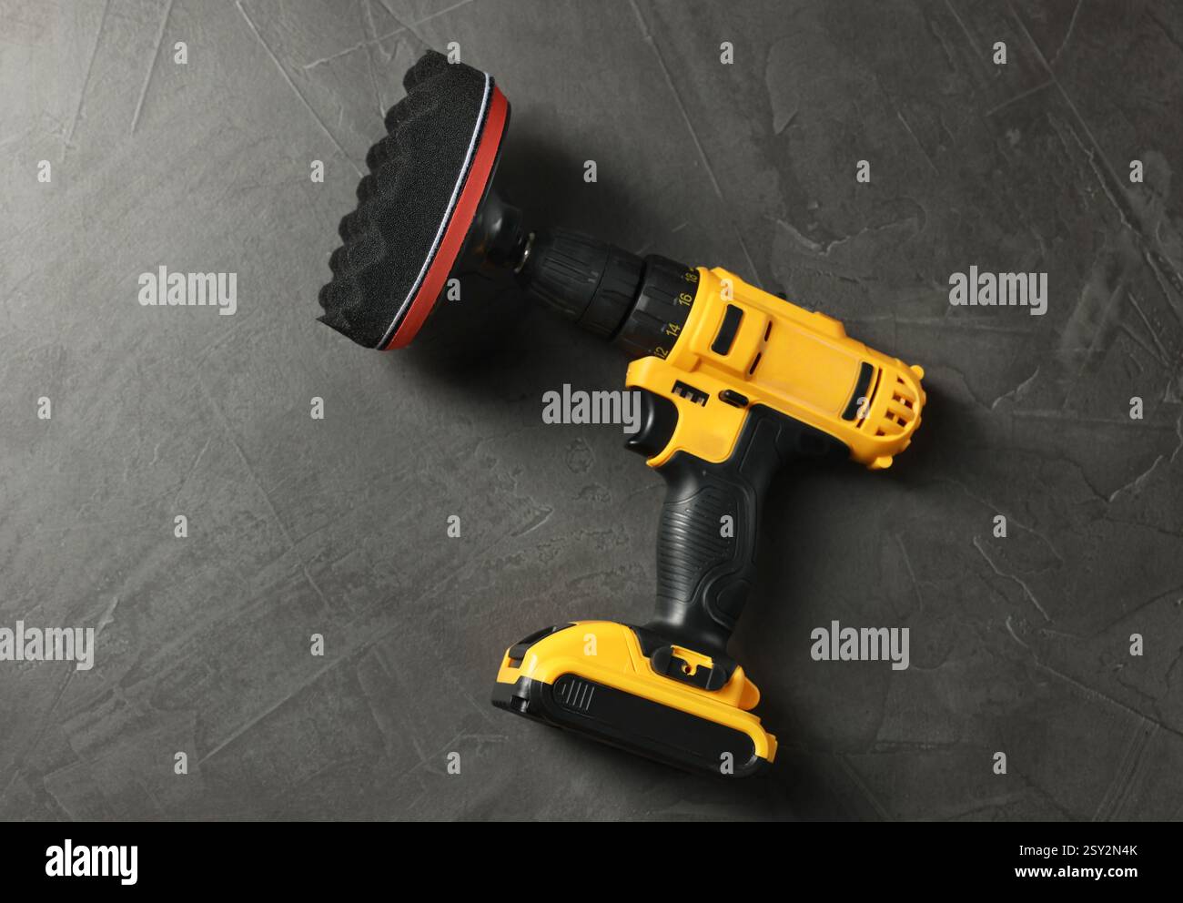 Elektrischer Schraubendreher mit polsterpolster auf grauem Tisch, Draufsicht Stockfoto