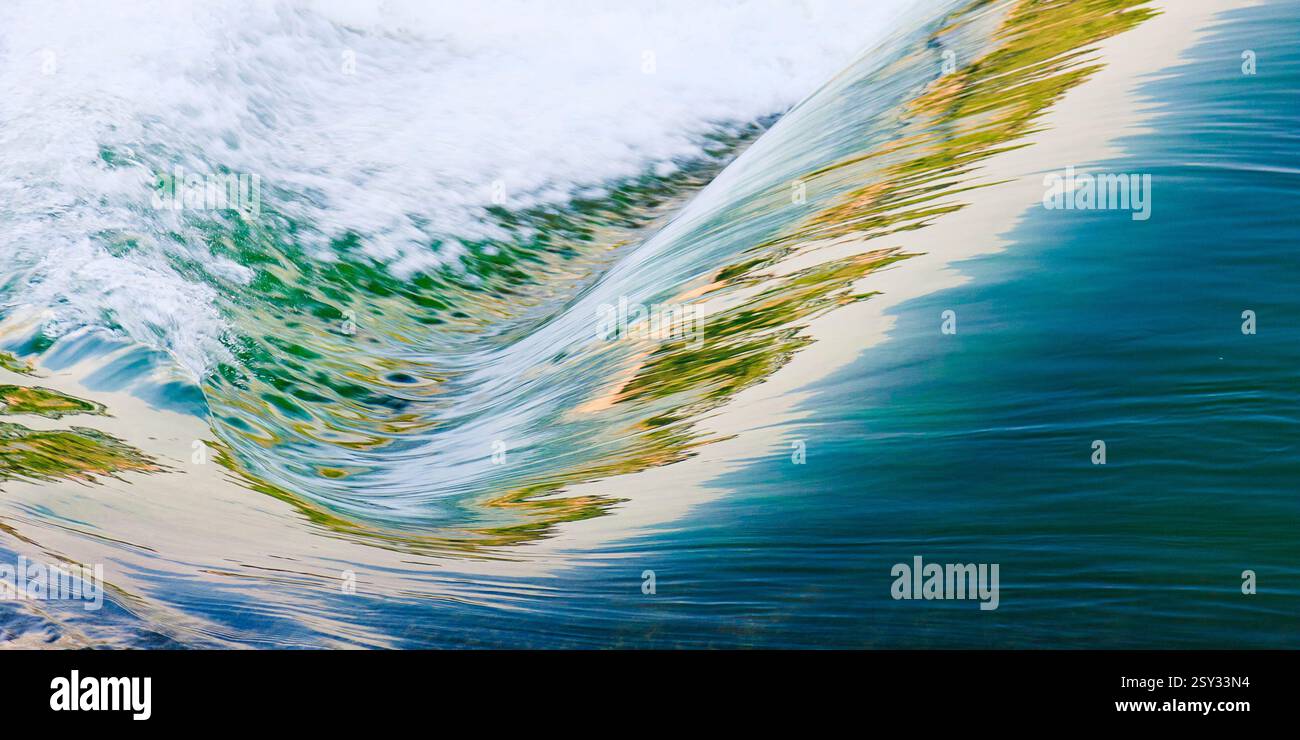 Das Bild zeigt eine Kurve mit grünem Farbton. Das Wasser ist abgehackt und die Welle stürzt. Das Bild hat ein Gefühl von Bewegung und Energie Stockfoto