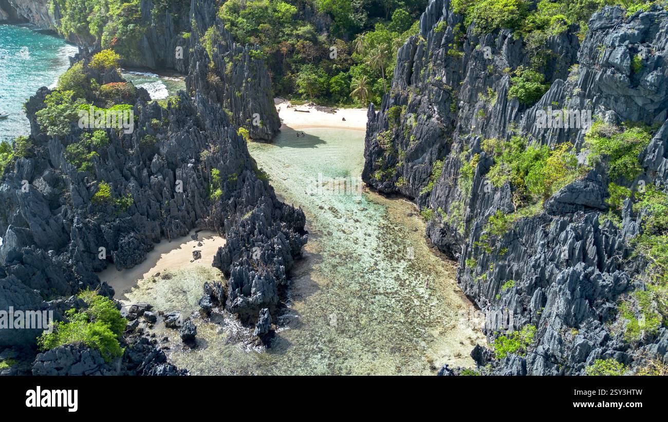 Der versteckte Strand von Matinloc Island, El Nido: Aus der Vogelperspektive auf eine abgelegene Bucht, zerklüftete Klippen und klares türkisfarbenes Wasser. Tropisches Paradies, geheimes Refugium. Stockfoto