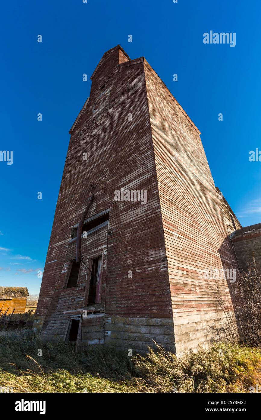Hohes Backsteingebäude mit großem Fenster. Das Gebäude ist alt und hat viele Risse Stockfoto